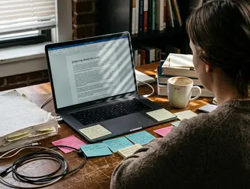 On-site Home office writing setup with laptop displaying a text draft titled Preparing Clients